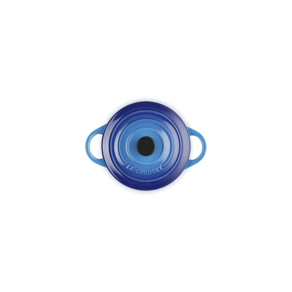 Casseruola rotonda in ceramica blu con manici, superficie liscia e centrale nera, su sfondo bianco.