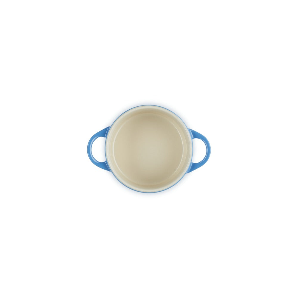Coccio tondo con manici blu, interno beige, posizionato su sfondo bianco.