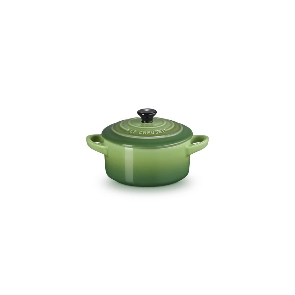Casseruola olandese verde con coperchio nero, manici laterali e logo "LE CREUSET" in rilievo.