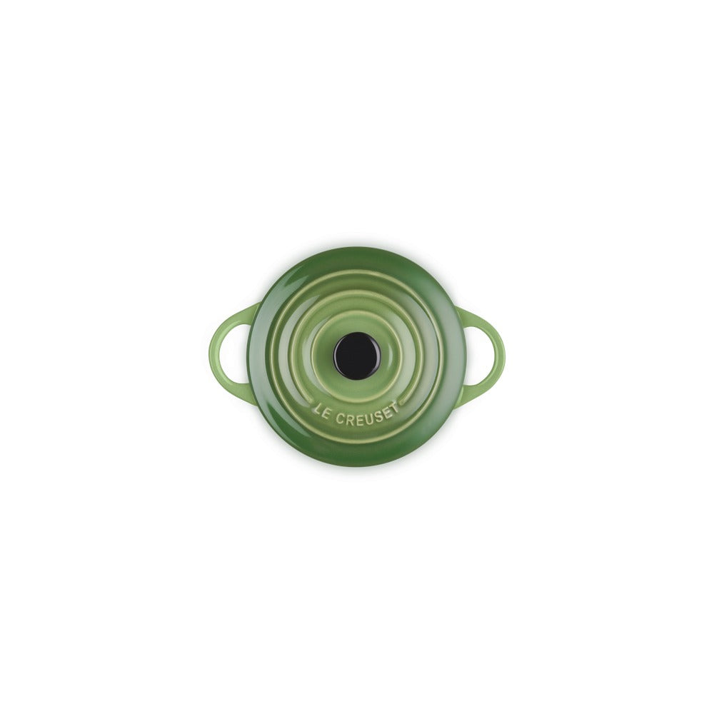 Casseruola in ghisa smaltata verde con manici, forma rotonda e superficie lucida, con un foro centrale.
