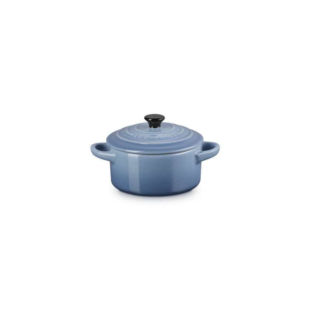 Casseruola in ceramica blu con coperchio e manico, superficie liscia e lucida, base rotonda, ambiente neutro.