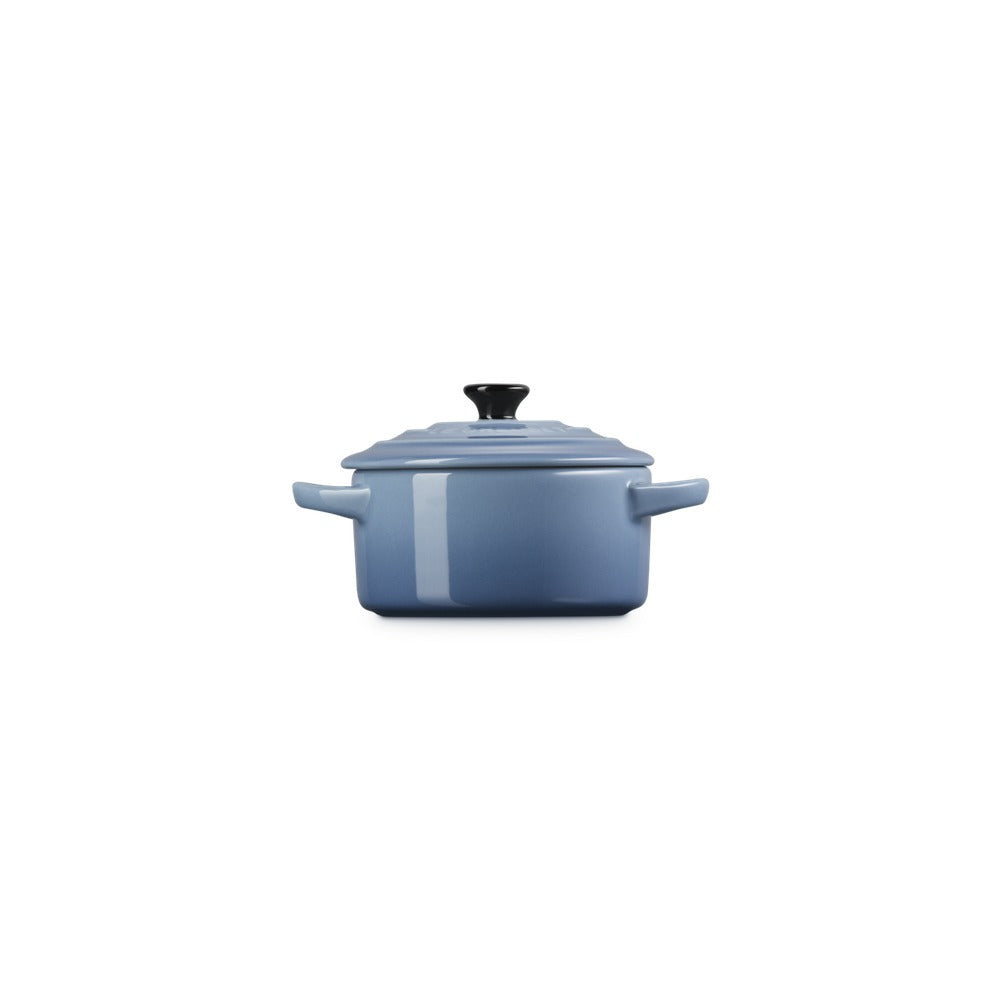 Casseruola rettangolare in ceramica blu con coperchio, manici e pomolo nero, su sfondo bianco.