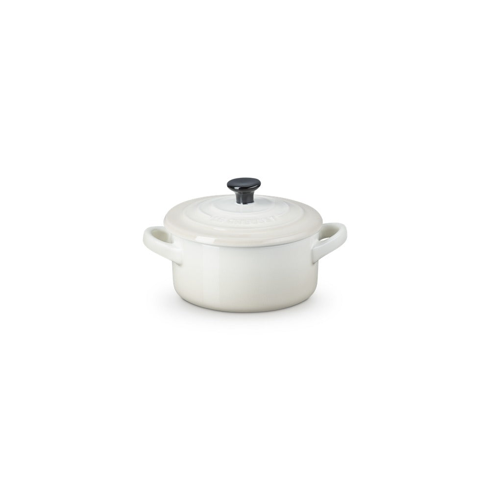 Pentola rotonda in ceramica bianca con coperchio, maniglie laterali e pomello nero in cima.