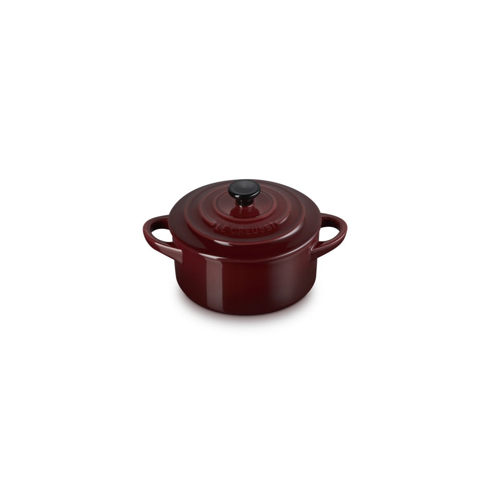 Casseruola rotonda di colore rosso borgogna con coperchio e manici, superficie liscia e lucida.