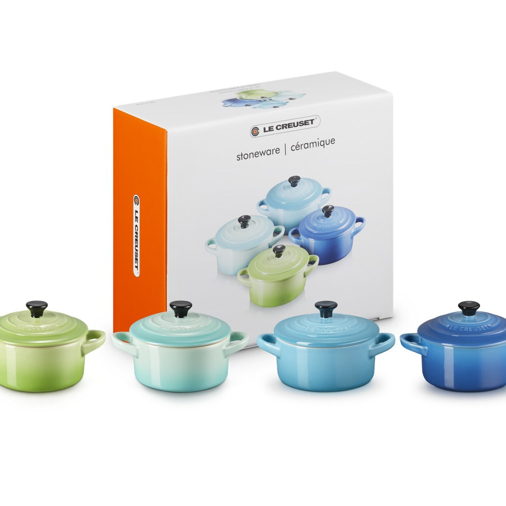 Set de casseroles en céramique colorées (vert, bleu clair, bleu, bleu foncé) avec couvercles noirs, emballées en boîte.