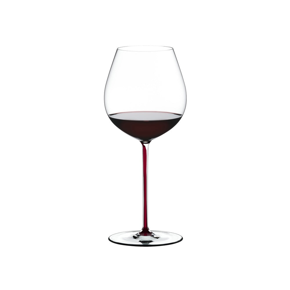 Calice di vino dal design elegante, in vetro trasparente con gambo rosso, contenente vino rosso profondo. Sfondo bianco.