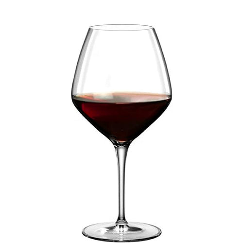Calice en verre transparent à long pied avec vin rouge à mi-hauteur, fond blanc neutre.