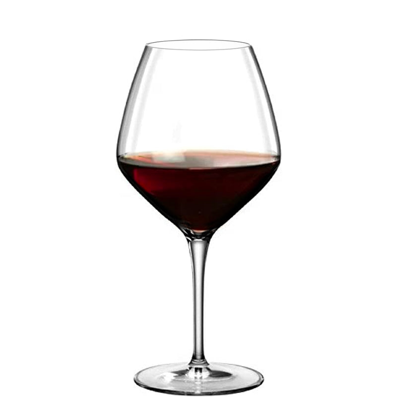 Transparentes Glas mit langem Stiel und Rotwein bis zur halben Höhe, neutraler weißer Hintergrund.