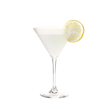 bicchiere da cocktail trasparente con liquido bianco opaco e fetta di limone giallo sul bordo su sfondo bianco