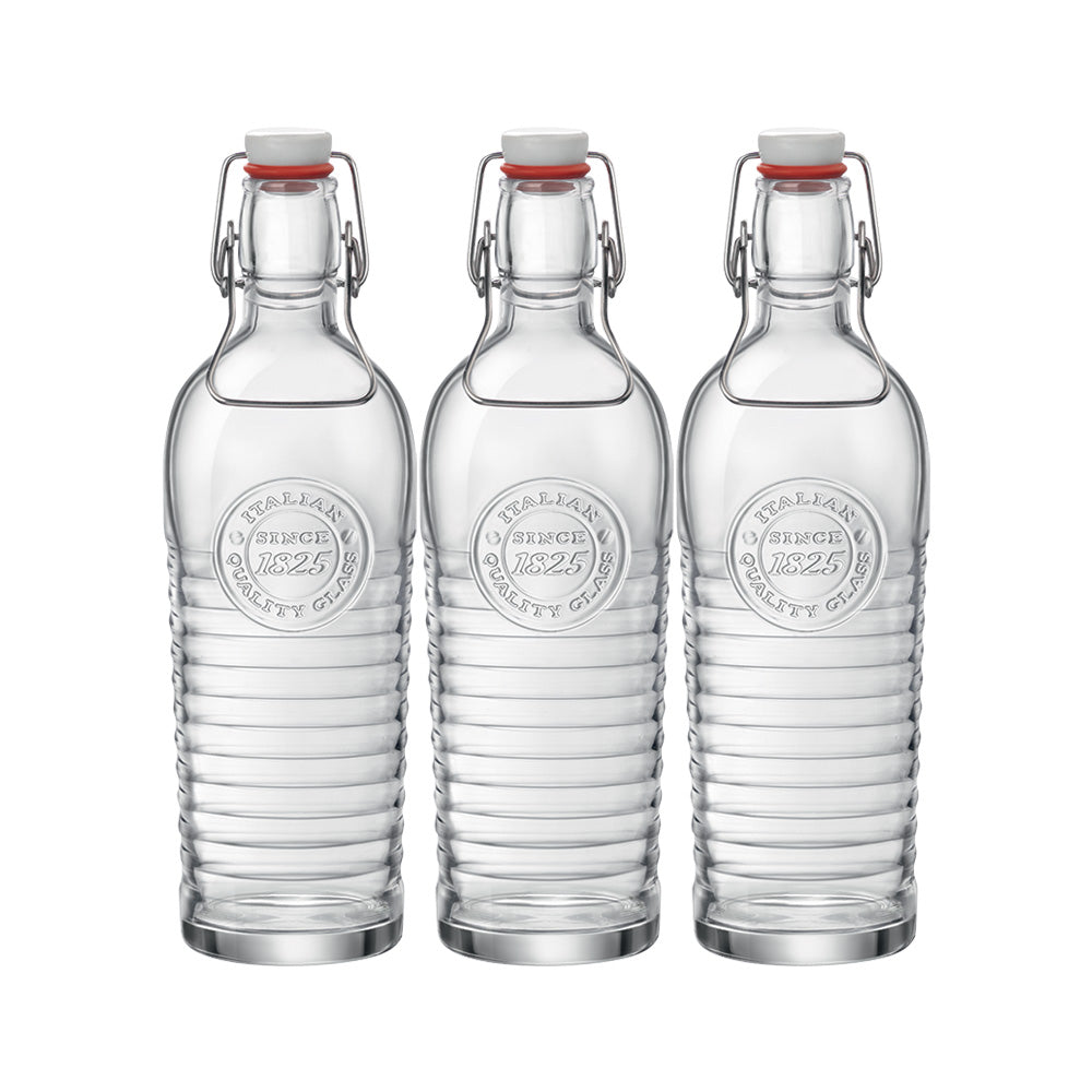 Tre bottiglie trasparenti in vetro con chiusura ermetica a gancio metallico e tappo bianco, con scritta in rilievo "Italian Quality Glass Since 1825