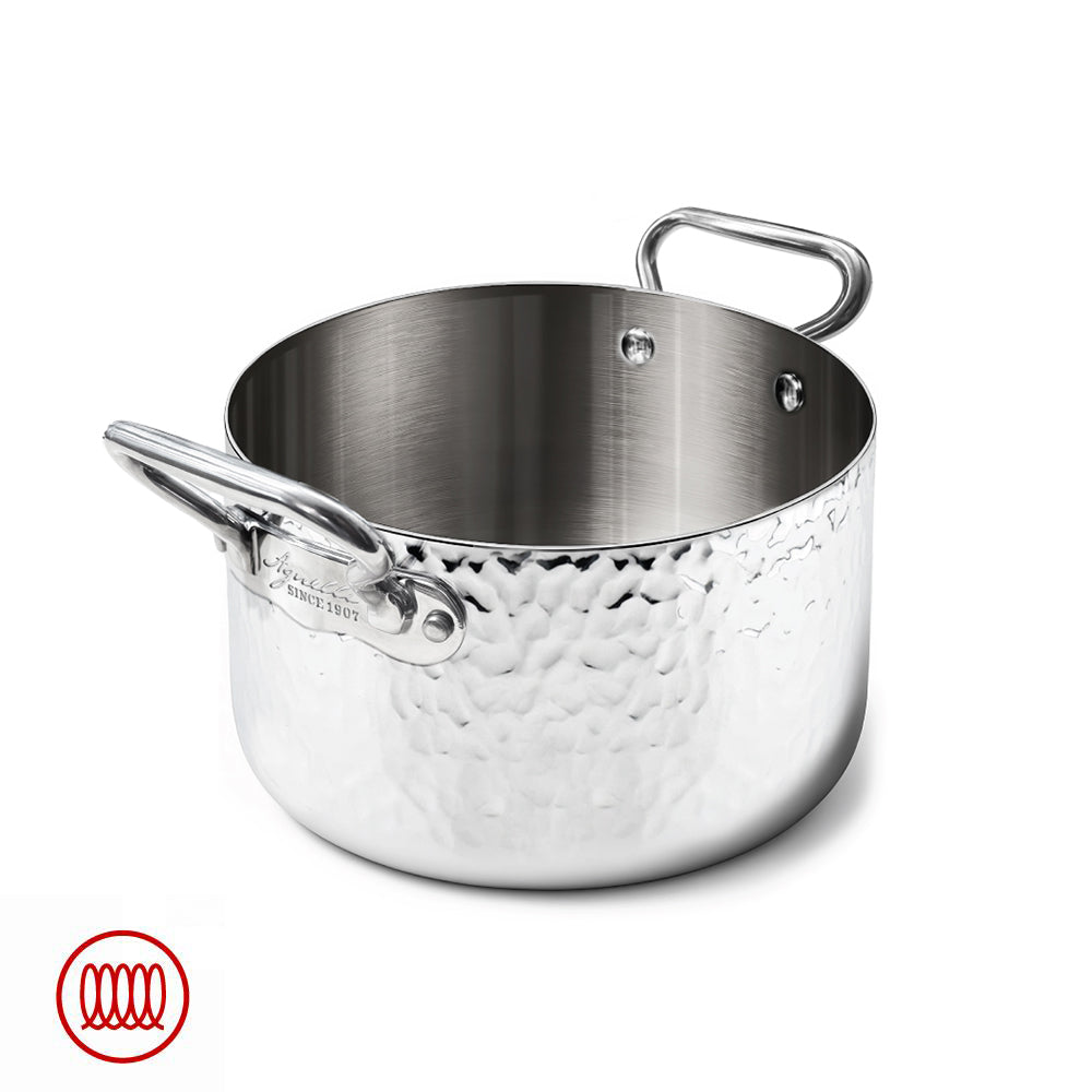 Gepolijste metalen pan met gehamerd oppervlak, tubulaire zijhandgrepen, gegraveerd Agnelli-logo, witte achtergrond.