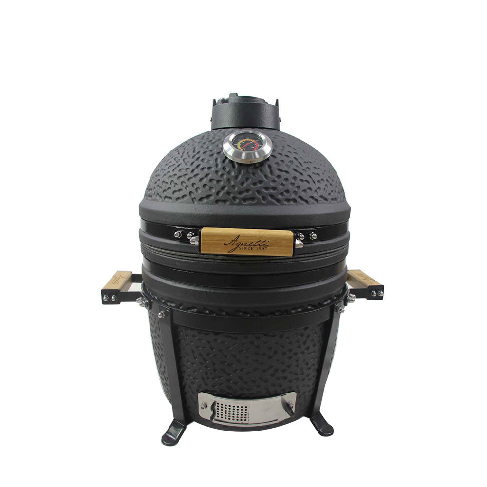 Barbecue noir en céramique avec poignées en bois, thermomètre sur la coupole et évent supérieur, pieds de support, fond blanc.