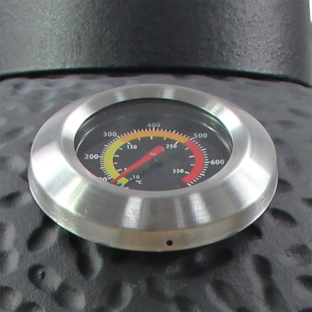 Thermomètre rond avec bague en acier inoxydable et cadran noir sur surface noire martelée, échelle de température en °C et °F.