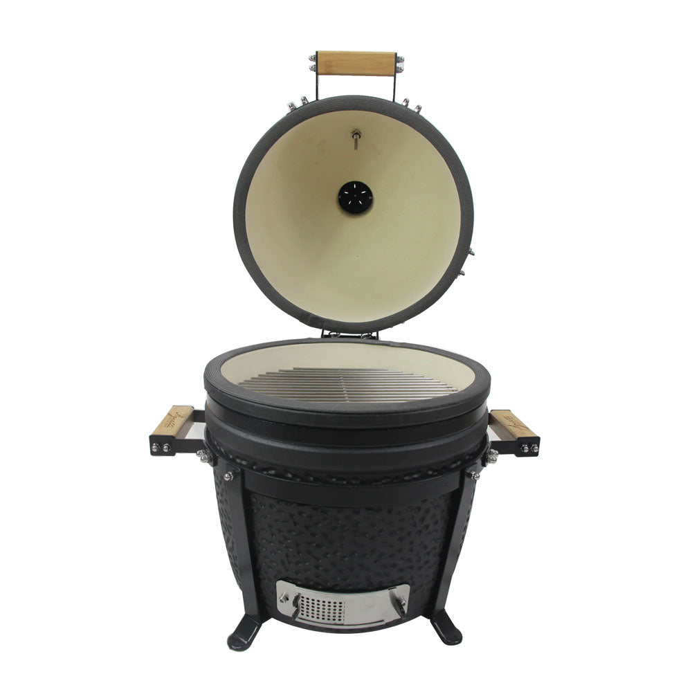 Barbecue ovale en céramique noire avec ouverture supérieure, grille en métal et poignées en bois clair, fond blanc.