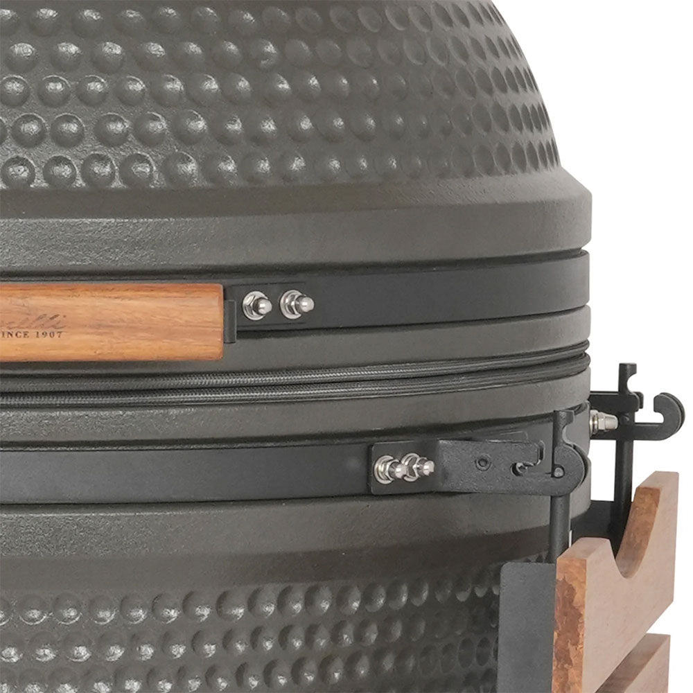 Grauer Keramik-Kamado-Grill mit Holzgriff, schwarzem Metallverschluss und Stahldetails auf weißem Hintergrund