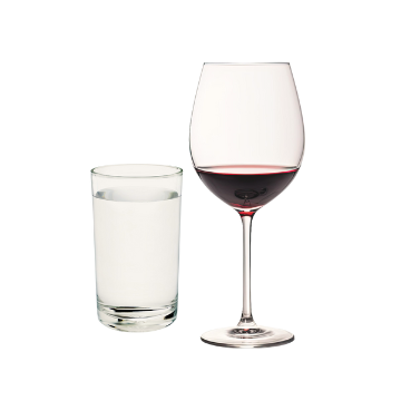 Bicchiere trasparente cilindrico con acqua e calice di vetro trasparente con vino rosso su sfondo bianco.