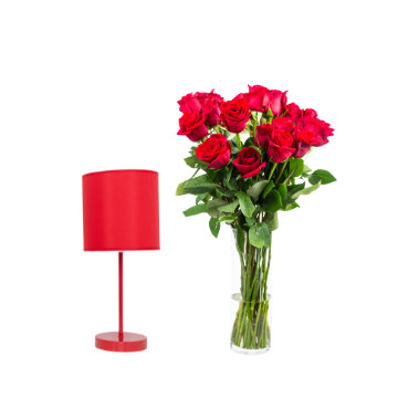 Lampada con paralume rosso accanto a vaso trasparente con mazzo di rose rosse e foglie verdi