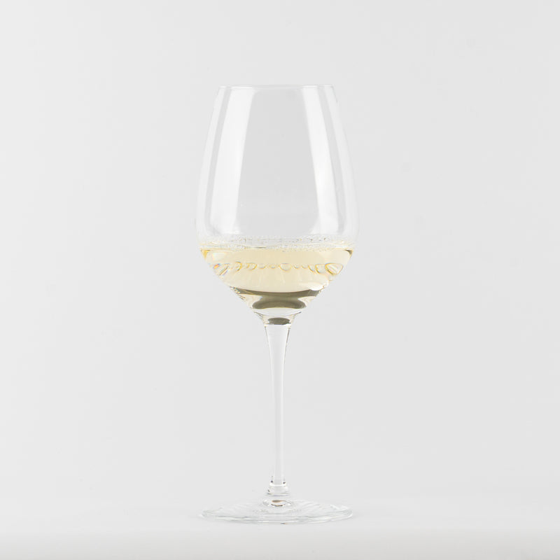Verre à vin en verre transparent avec vin blanc clair sur fond blanc neutre