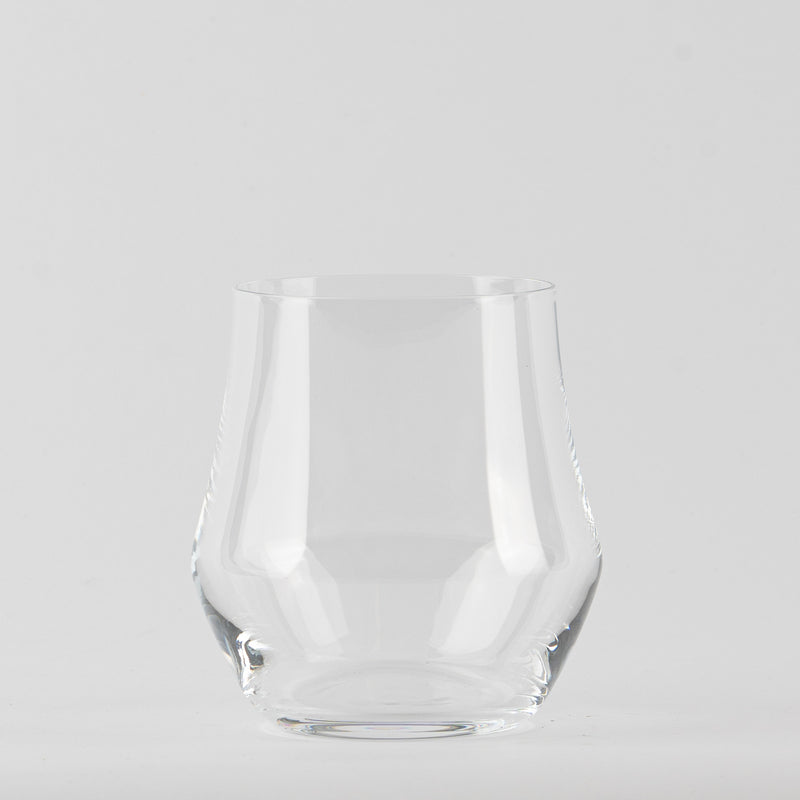 Verre transparent en verre avec base large et bord légèrement plus étroit sur fond gris clair