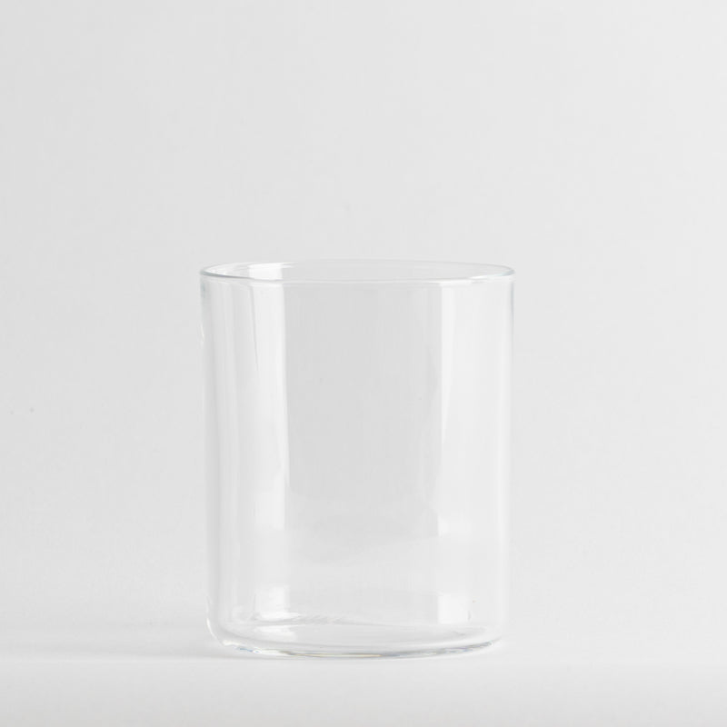 Verre transparent cylindrique en verre avec bord légèrement arrondi sur fond blanc