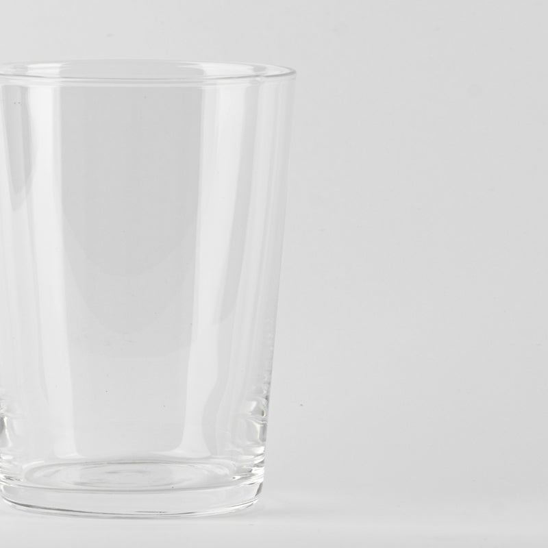 Vaso transparente de cristal con borde redondeado sobre fondo blanco uniforme