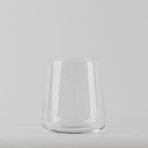 Transparentes Glas mit runder Basis und leicht konischen Wänden auf hellgrauem Hintergrund