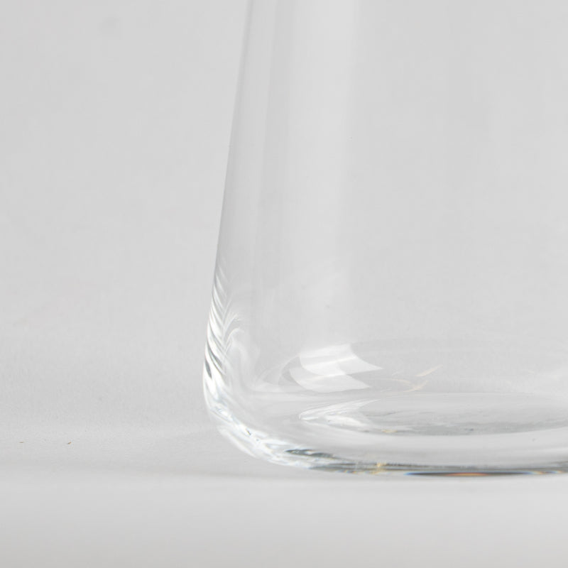 Partie inférieure d'un vase transparent en verre sur fond blanc