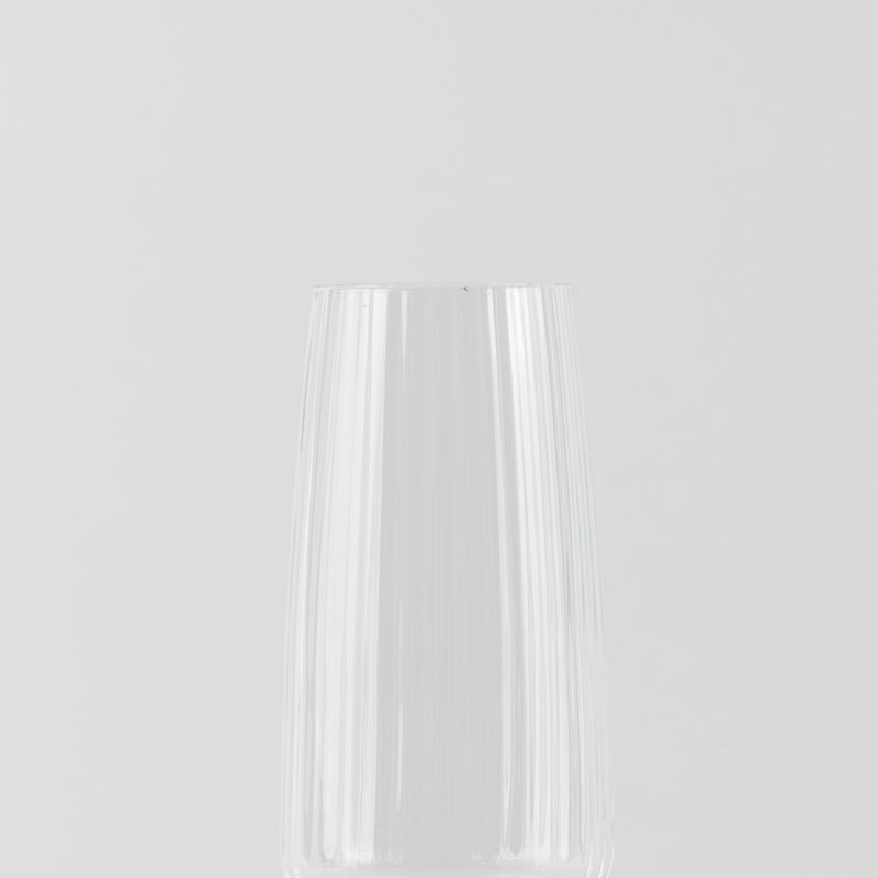 Verre transparent en verre avec surface lisse et reflets lumineux sur fond gris clair uniforme