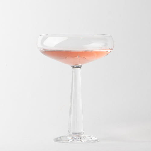 transparent glass coupe cocktail glass avec rose liquid, uniform fsurd blanc