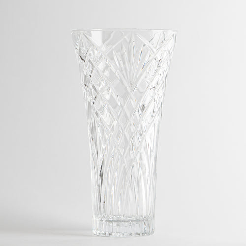 vaso trasparente in vetro con decorazioni incise a motivi geometrici su sfondo bianco