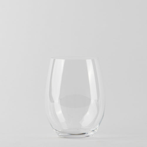 Verre transparent en verre sans tige avec base ronde et parois légèrement courbes sur fond gris clair