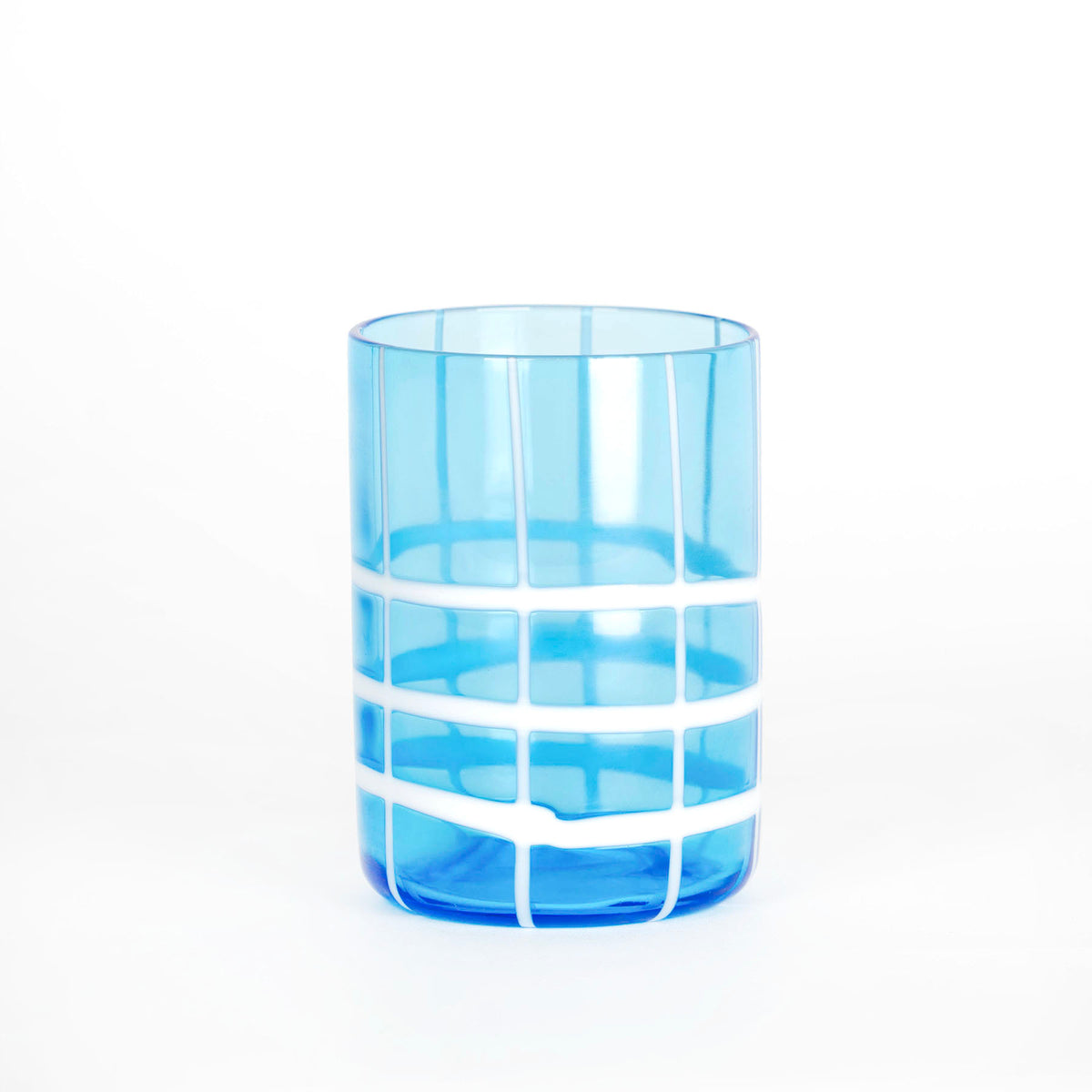 Verre cylindrique bleu clair transparent avec détails blancs de lignes verticales et horizontales sur fond blanc uniforme