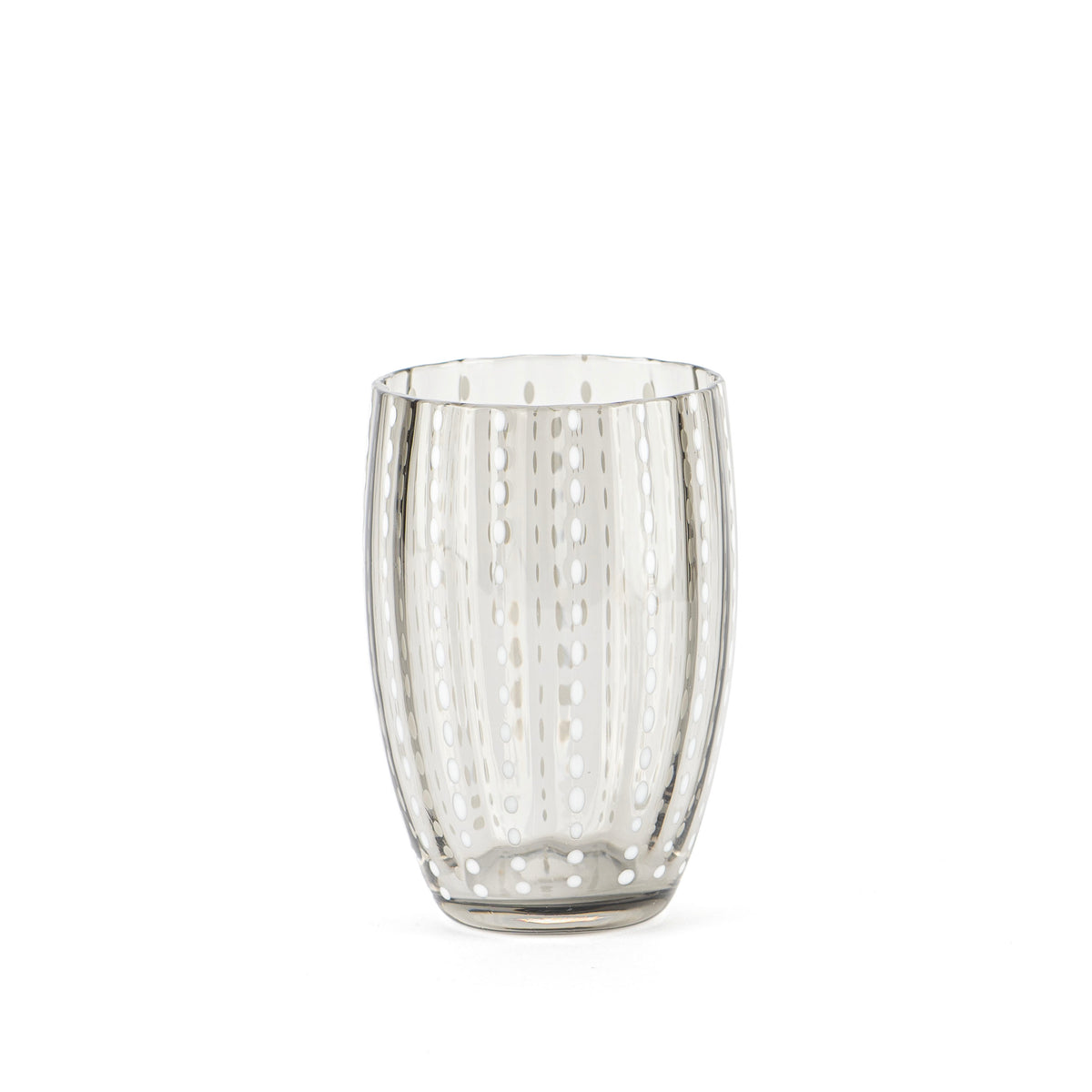 Transparante glazen beker met white dotted decoratiops distributed vertically op witte achtergropd.