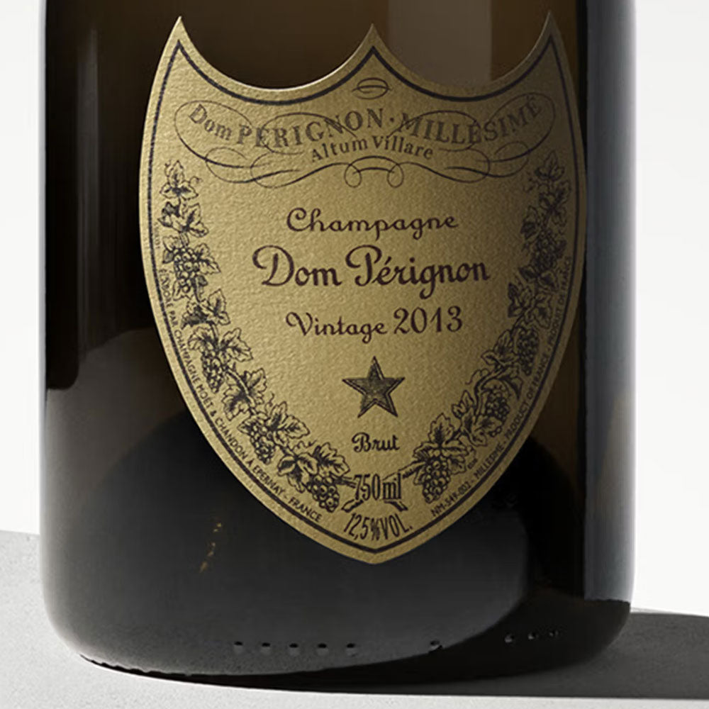 Etichetta beige a forma di scudo con scritte marroni su bottiglia di champagne Dom Pérignon Vintage 2013 da 750 ml