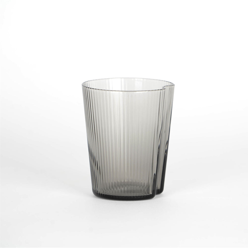 Verre transparent en verre gris avec vertical knurled surface, fsurd blanc, slightly csurical forme cylindrique.