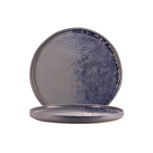 Due piatti rotondi in ceramica color blu sfumato con motivo marmorizzato su sfondo bianco.