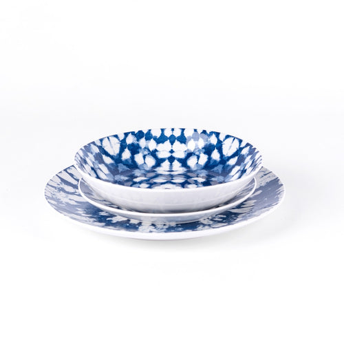 Set aus Keramiktellern mit blau-weißen Dekorationen. Zwei übereinander gestapelte Schüsseln und ein größerer Teller. Weißer Hintergrund.