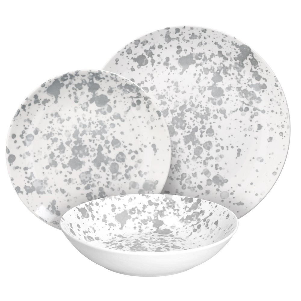 Set di piatti bianchi con decorazioni macchiate grigie, composto da un piatto fondo, un piatto piano e un piatto da dessert.