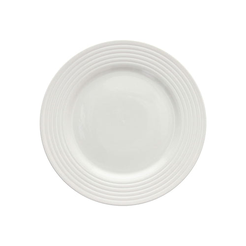 Piattino bianco rotondo in ceramica con decorazione a rilievo a fasce concentriche sul bordo, sfondo bianco.