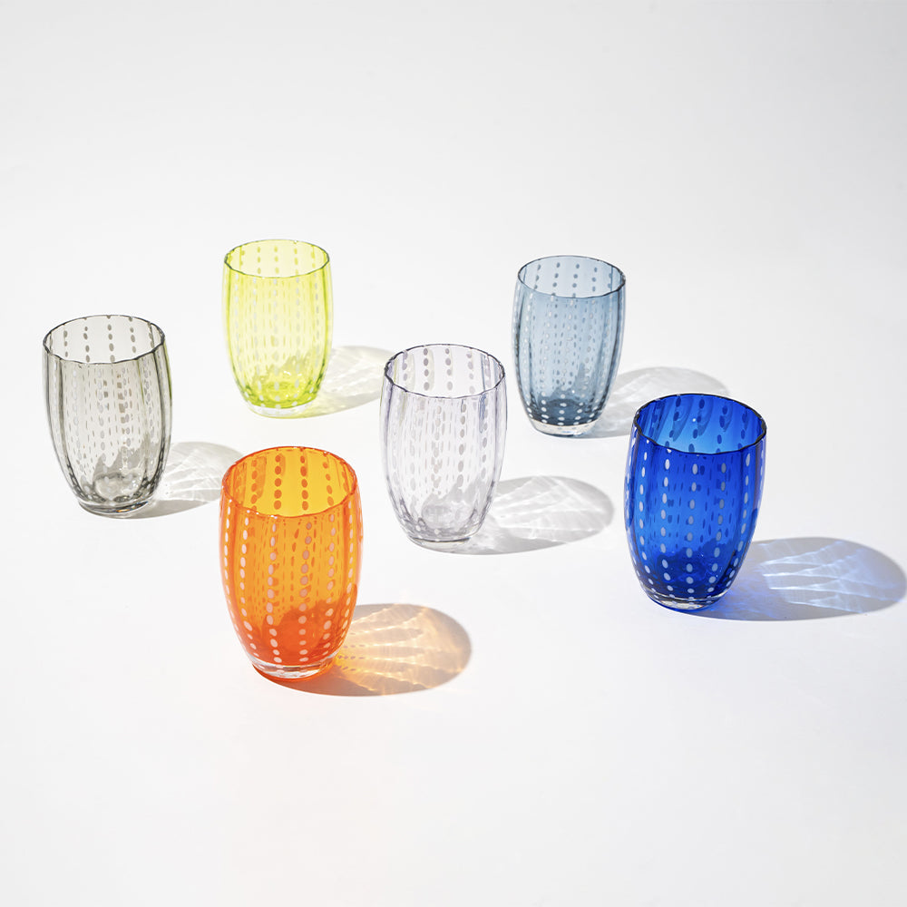 Zes gekleurde transparante glazen bekers met witte stippen op witte achtergrond, kleuren: oranje, geel, blauw, grijs, lichtblauw en