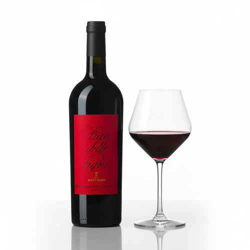Bottiglia di vino rosso con etichetta rossa e calice trasparente con vino rosso, sfondo bianco riflettente.