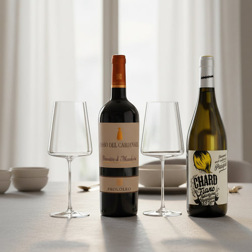 Due bottiglie di vino, una rossa Passo del Cardinale Primitivo di Manduria con etichetta beige e una bianca Chard Fiano con etichetta illustrata, e