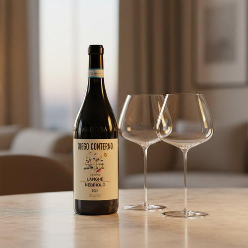 Bouteille de vin rouge Diego Conterno Langhe Nebbiolo 2022 avec étiquette beige et deux calices en verre transparent sur table claire en intérieur avec