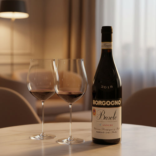 Bouteille de vin rouge Borgogno Barolo 2018 et deux calices avec vin sur table, fond intérieur avec lampe et fauteuil beige.