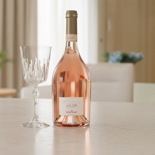 Alìe Frescobaldi Roséweinflasche aus transparentem Glas und Kristallglas mit verziertem Stiel auf hellem Tisch in hellem Innenraum.
