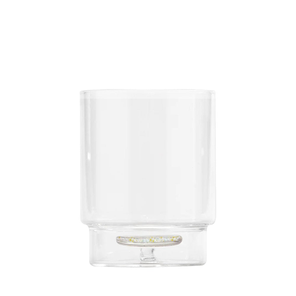 Bicchiere trasparente rotondo in vetro con base spessa e decorazione gialla interna, sfondo bianco neutro.