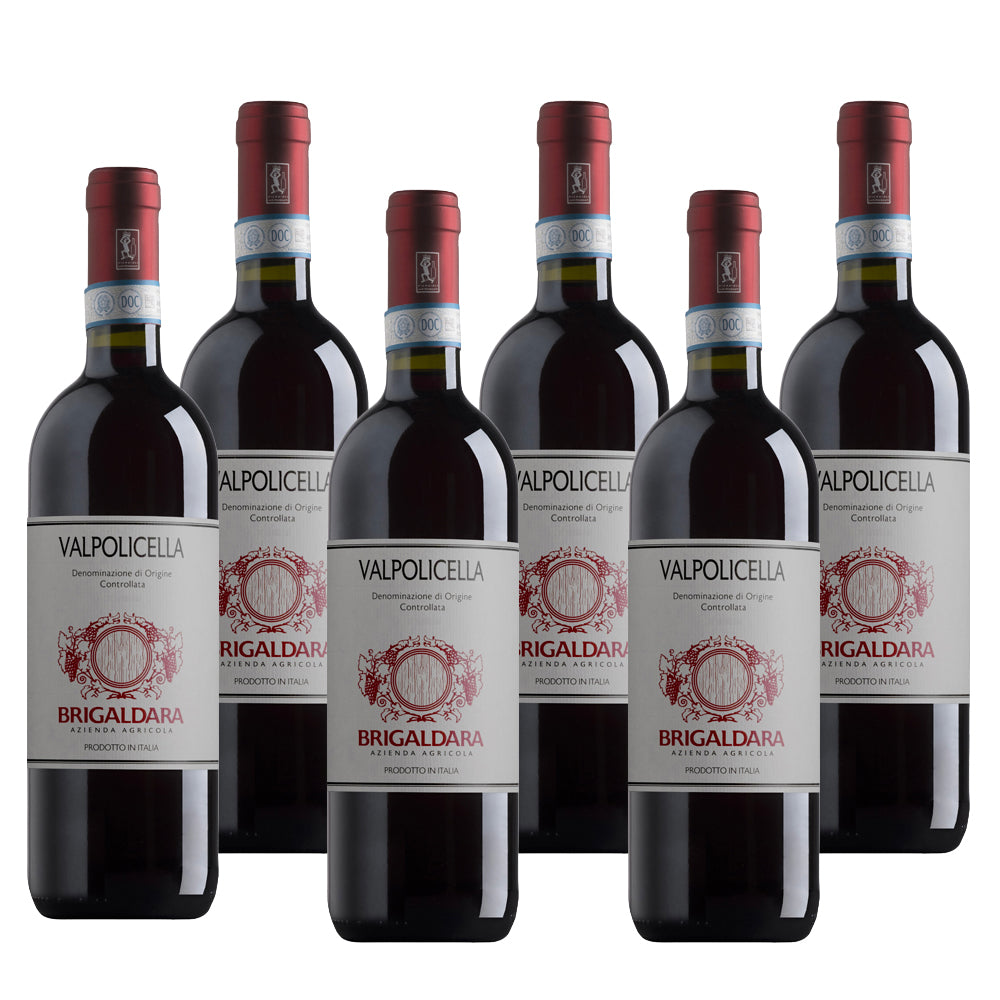 Zes Valpolicella rode wijnflessen, wit-rood label, met rode doppen, gegroepeerd.