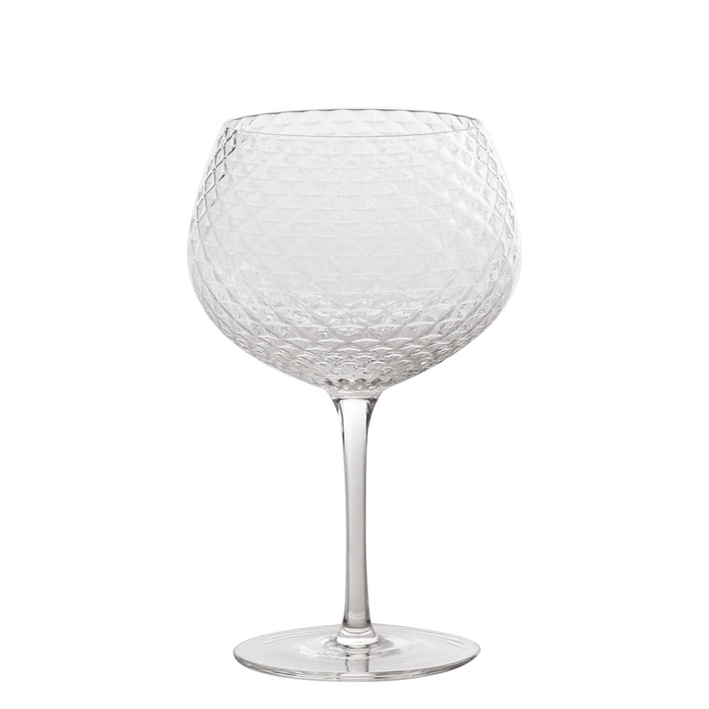Verre à vin en verre transparent à texture losangée, longue tige et base ronde plate sur fond blanc.