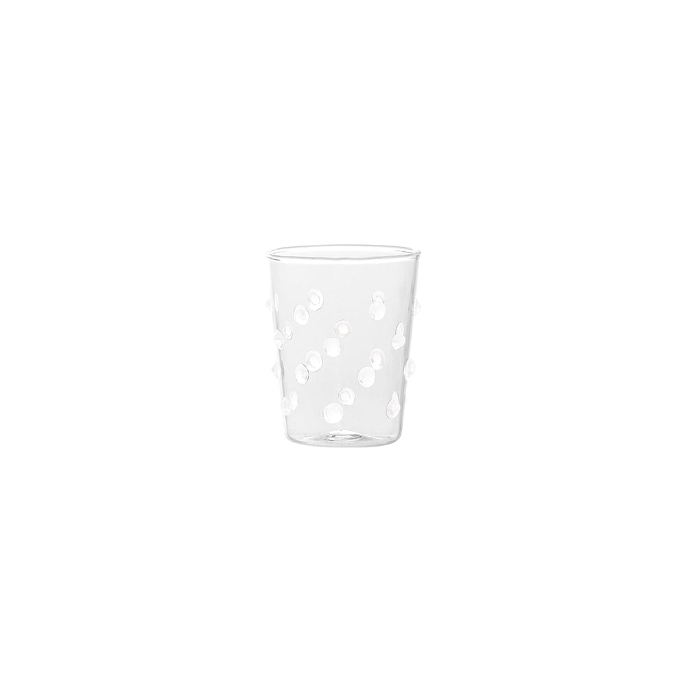 Verre transparent en verre avec décorations de petits reliefs ronds, fond blanc.