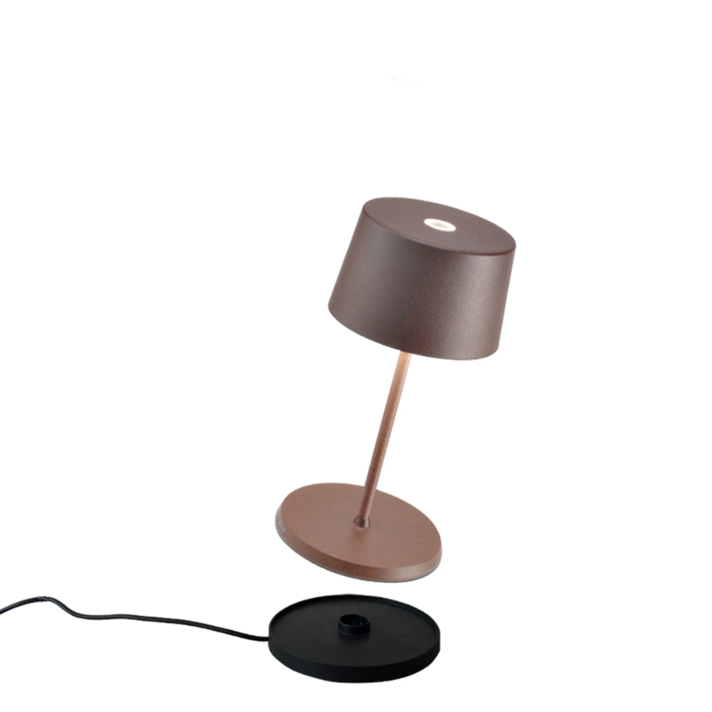 Lampe de table marron mate avec abat-jour cylindrique, base ronde séparée noire et câble électrique sur fond blanc.